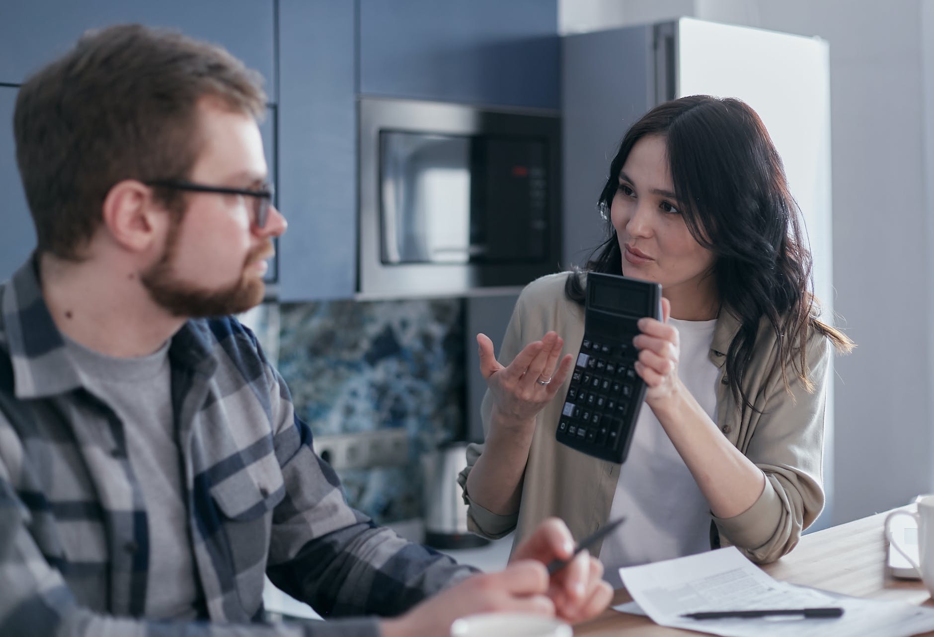 woman sitting at table holding a calculator