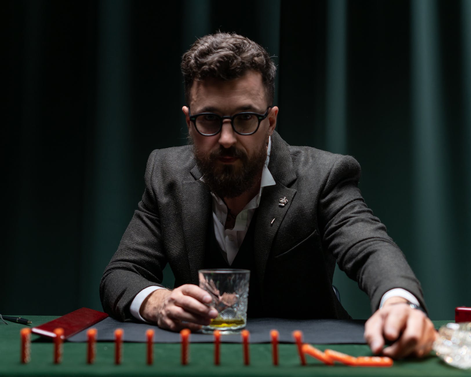 a man in a suit sitting at his desk playing with domino tiles